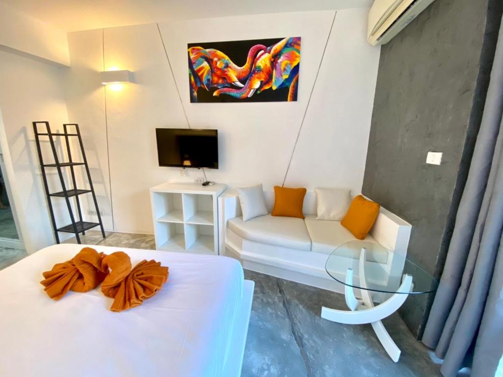 班拉克海滩STUDIO DESIGN 5 ETOILES Resort的客房设有床、沙发和电视。