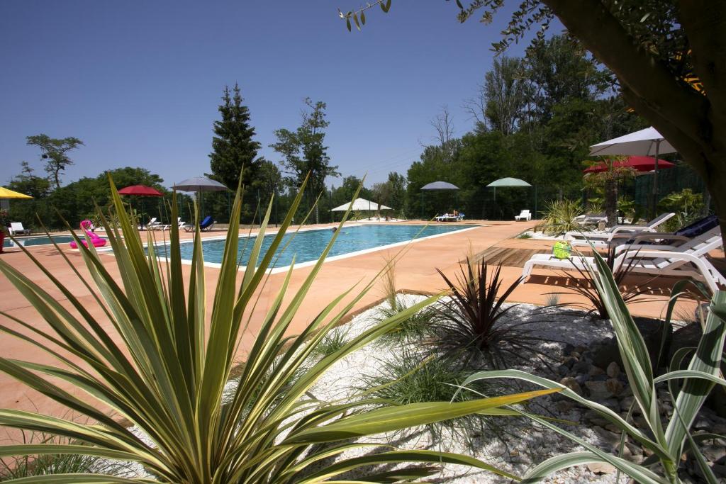 马泽尔拉巴斯蒂德度假酒店的度假村内带椅子和遮阳伞的游泳池