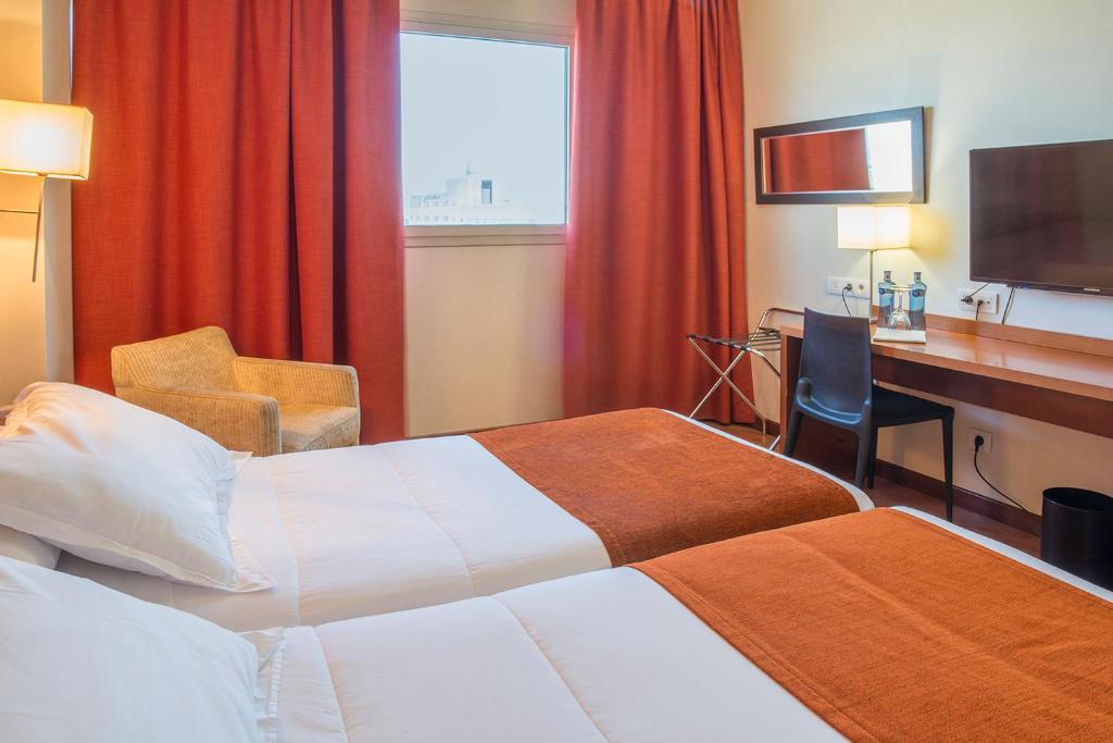 阿尔代阿瓦伦西亚克松斯酒店的酒店客房配有两张床和一张书桌