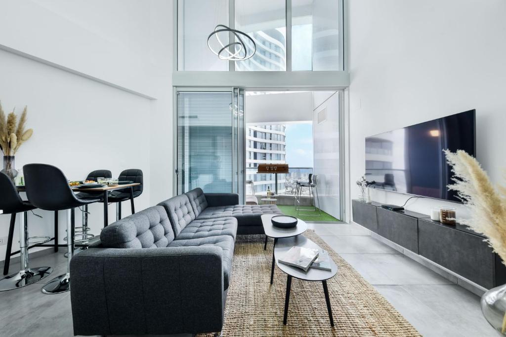 特拉维夫Spacious 3BR Duplex w Balcony in City Center by Sea N' Rent的客厅配有沙发和桌子
