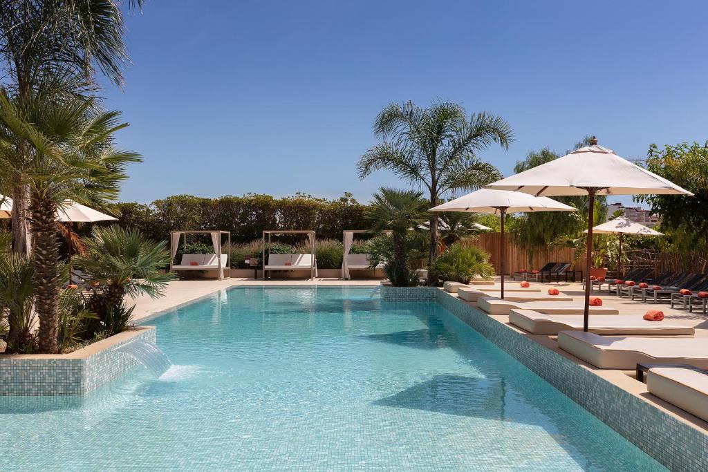 马尔格莱特德玛Luna Club Hotel Yoga & Spa 4Sup的一个带椅子和遮阳伞的大型游泳池