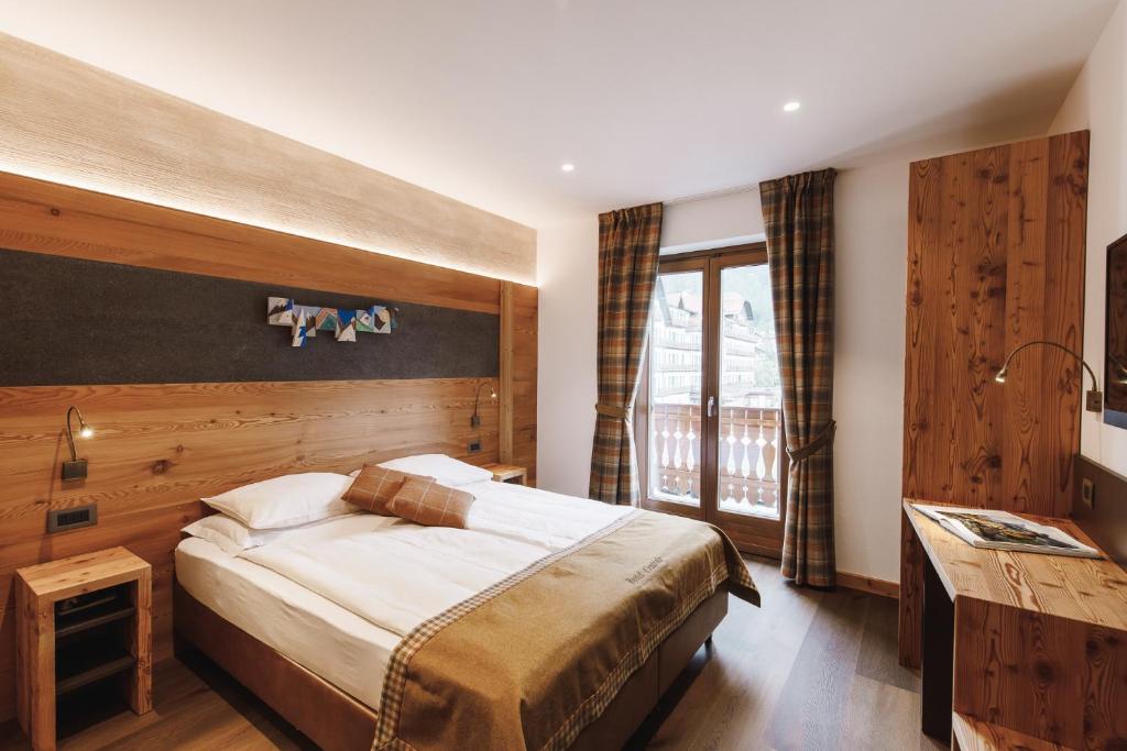 圣马蒂诺-迪卡斯特罗扎艾尔伯格中央酒店 的一间卧室设有一张大床和一个窗户。