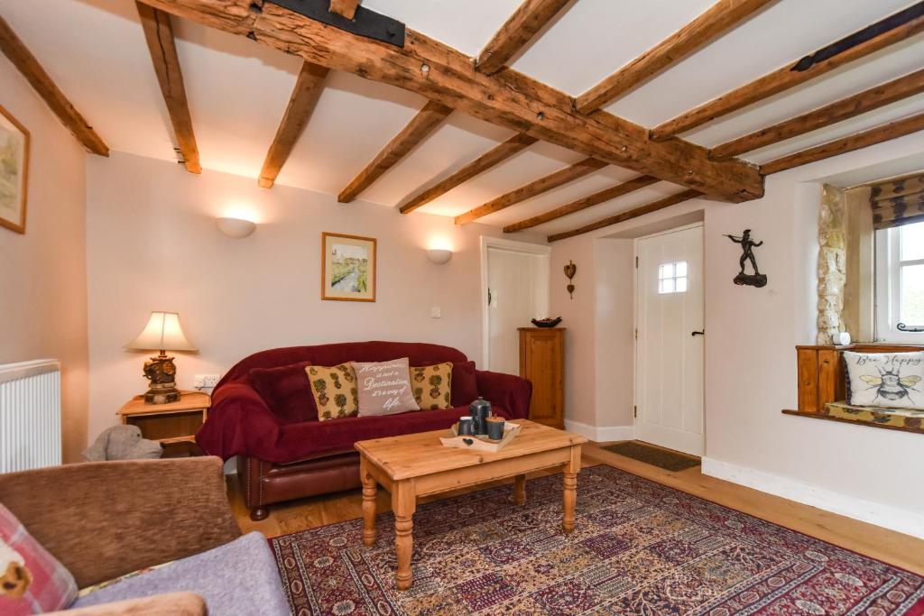 奥尔弗里顿Old Horns Cottage, Higham Derbyshire的客厅配有红色的沙发和桌子