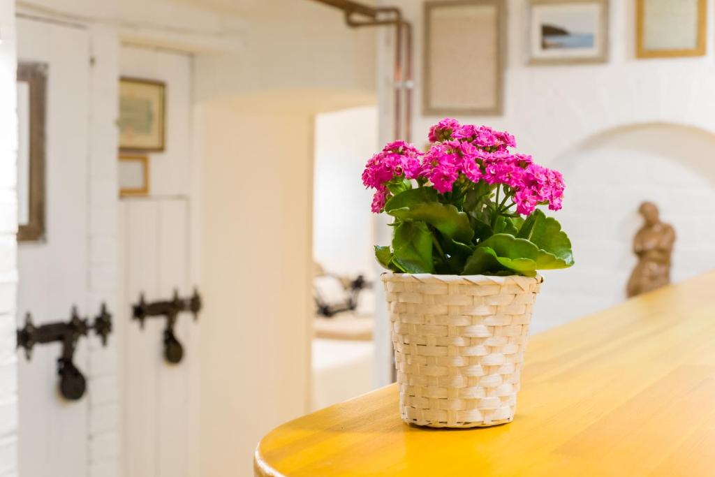 巴拉顿城堡Ádám Apartman的花瓶,花朵粉红色,坐在桌子上