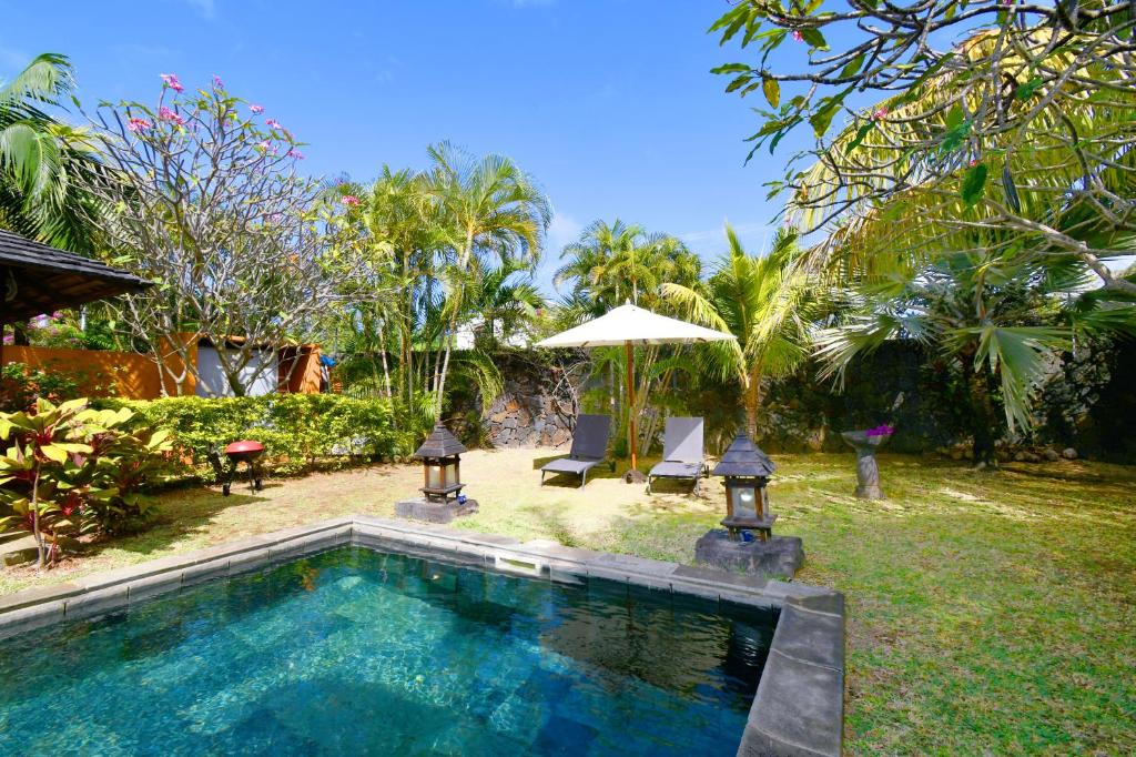 蓝海湾Elegant Villa Bali style in Blue Bay的庭院内的游泳池,配有两把椅子和一把遮阳伞