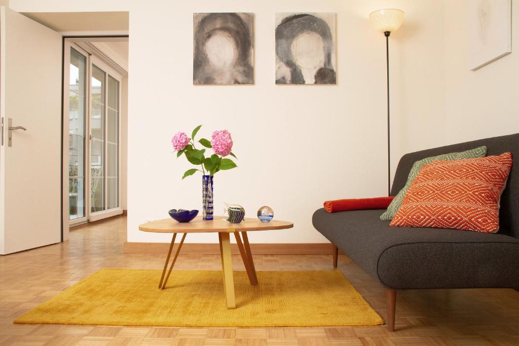 卢塞恩玛利亚别墅的客厅配有沙发和鲜花桌