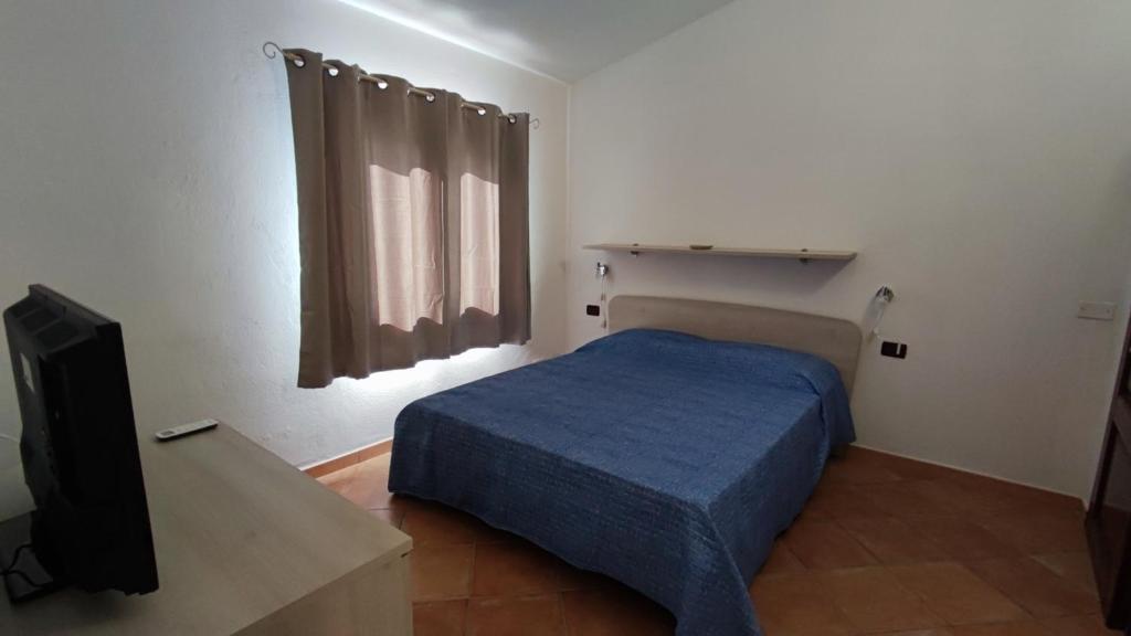 圣特奥多罗casa l'Ulivariu affittacamere的一间卧室配有一张床和一台平面电视