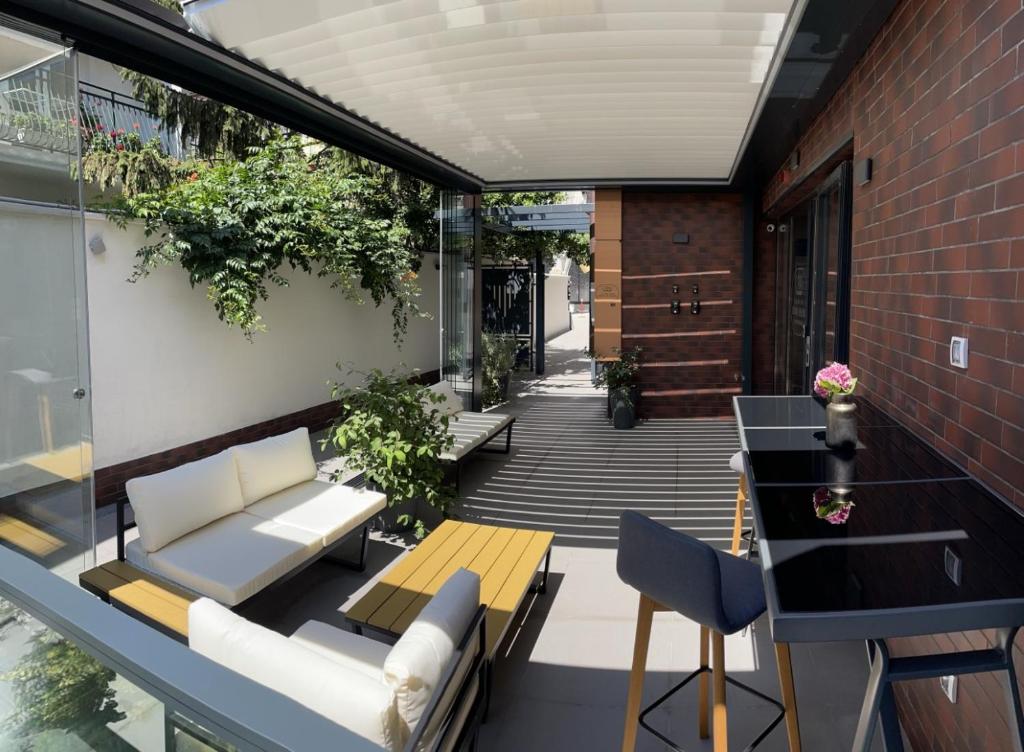瓦尔纳Caro Apartments & Rooms的户外庭院拥有白色家具和植物