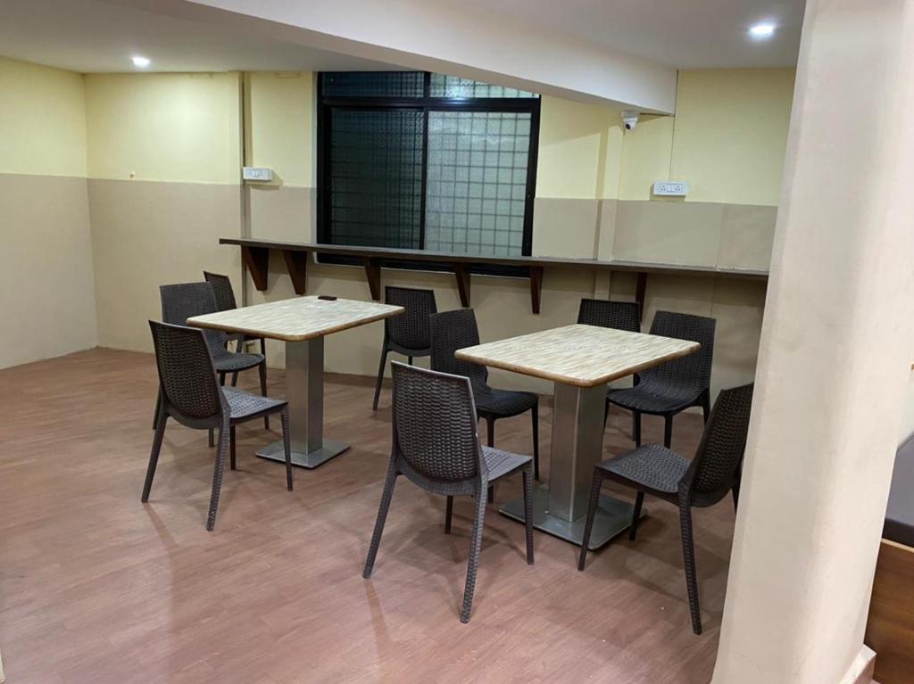 马尔冈City Stay AC Deluxe Hostel的一间房间,里面配有两张桌子和椅子