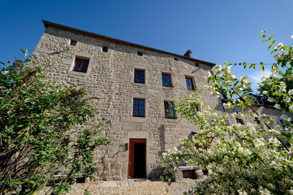 Le petit château du Villard的一座古老的石头建筑,有门和树木