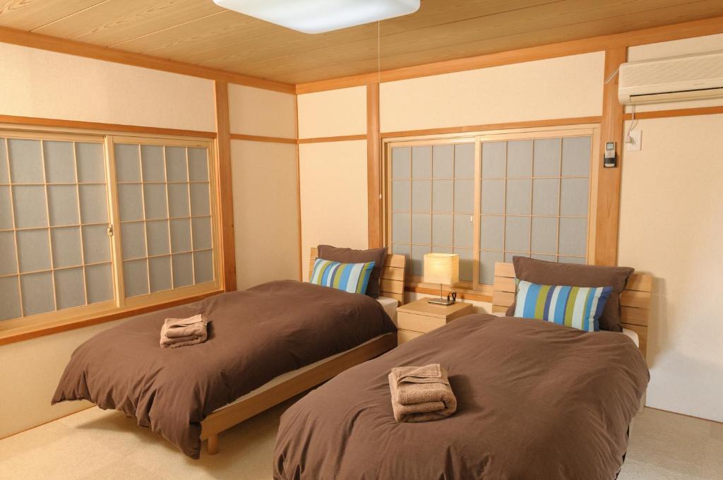白马村乐博卡格木屋 - 白马八方木屋的带窗户的客房内的两张床