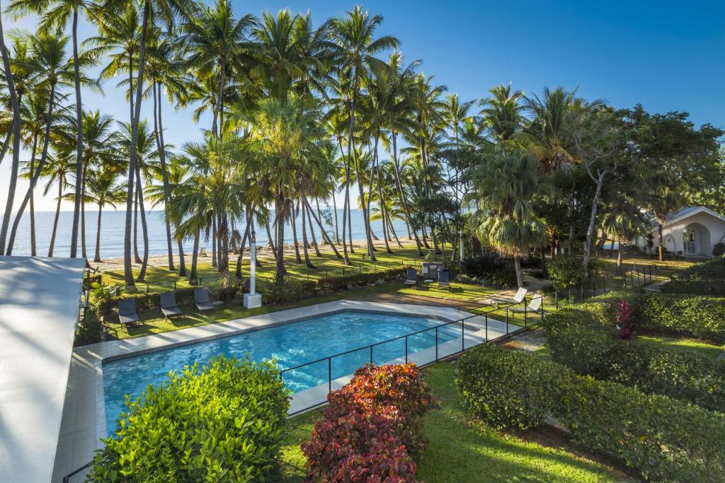 棕榈湾阿拉曼达棕榈湾兰斯摩尔酒店的享有棕榈树游泳池和大海的空中景致
