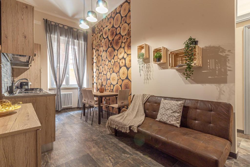 特尔尼Galvani Apartments的一间带棕色沙发的客厅和一间厨房