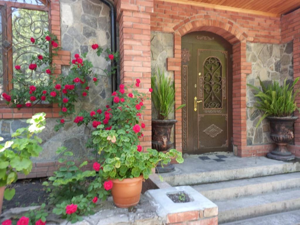 舍基Yurd in Sheki的鲜花和植物的房子的前门