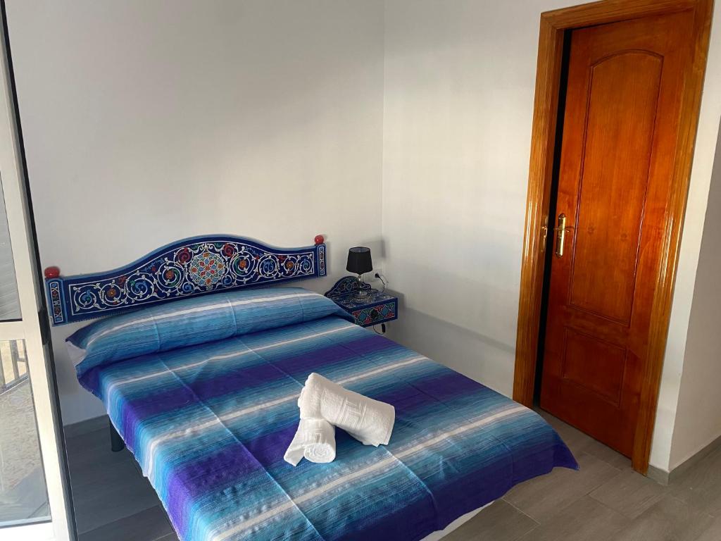 塞维利亚Casa Salma的一张床上挂着一双鞋的床