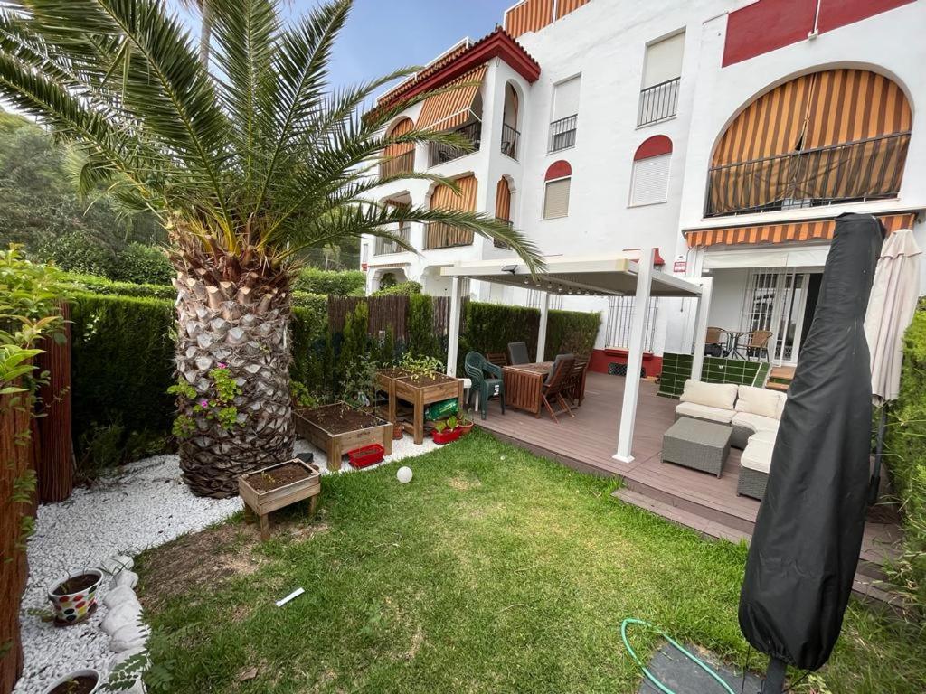 伊斯兰蒂拉Precioso apartamento con ubicación perfecta en playa Islantilla的一座楼前有棕榈树的院子