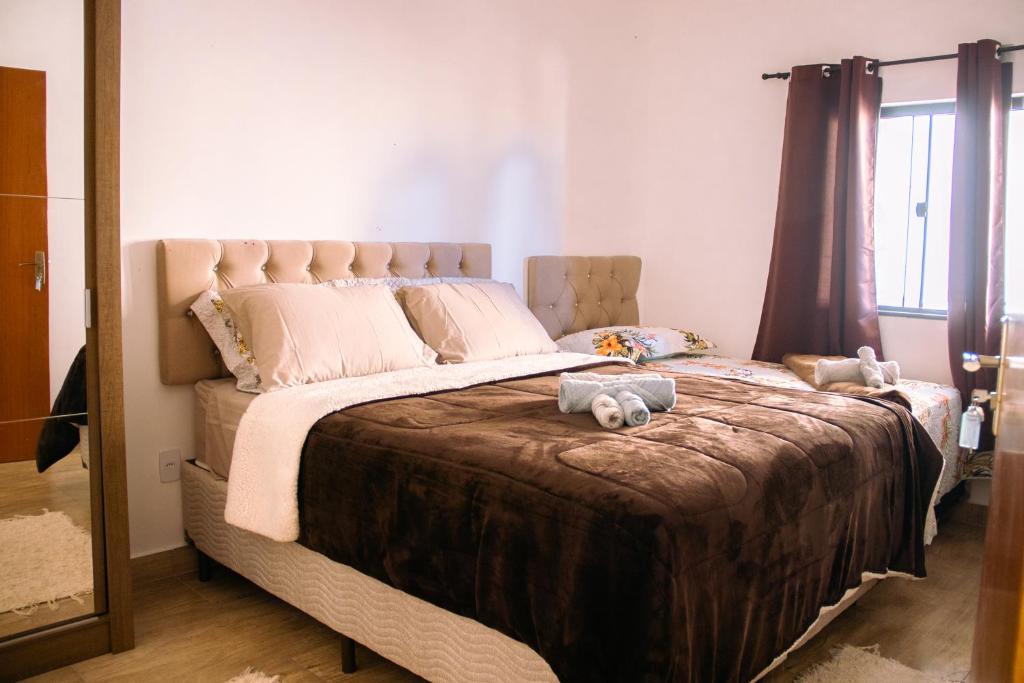 蒂拉登特斯Pouso Primavera的一间卧室设有一张大床,上面有两只填充动物