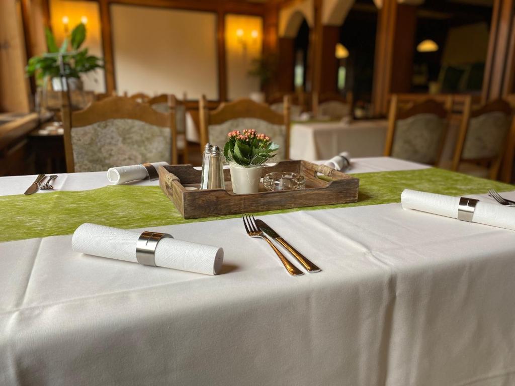 巴特洪内夫Hotel-Garni Domblick的一张桌子,上面有白色的桌布和一个带鲜花的木制托盘