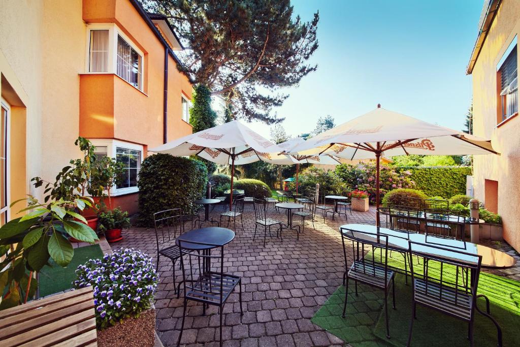 普鲁洪尼斯 潘普鲁洪尼斯图利酒店的一个带桌椅和遮阳伞的庭院