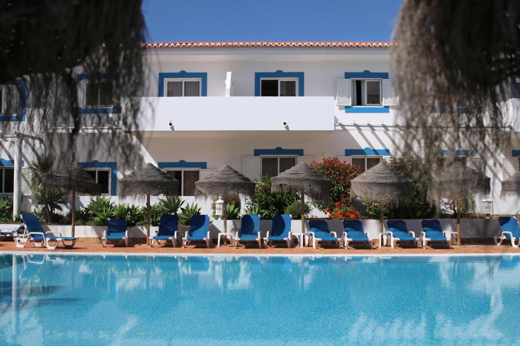 拉戈斯Agua Hotels Vila Branca的一座带椅子的游泳池以及一座建筑