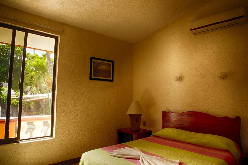 埃斯孔迪多港Rincon del Pacifico的一间卧室设有一张床和一个窗口