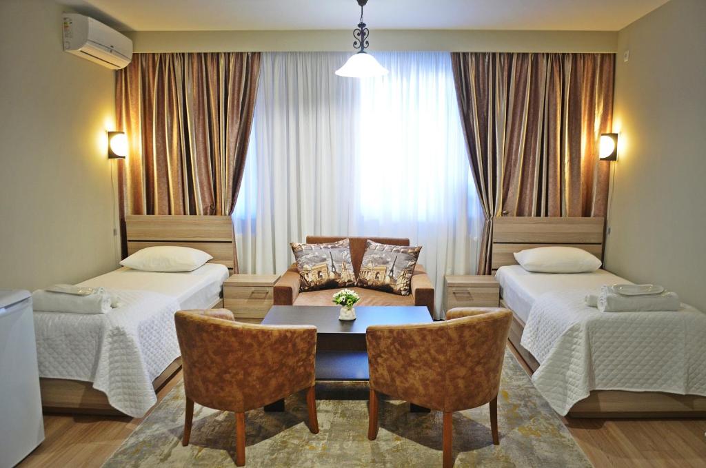 第比利斯Apartment Paysage的酒店客房带两张床和一张桌子以及椅子。