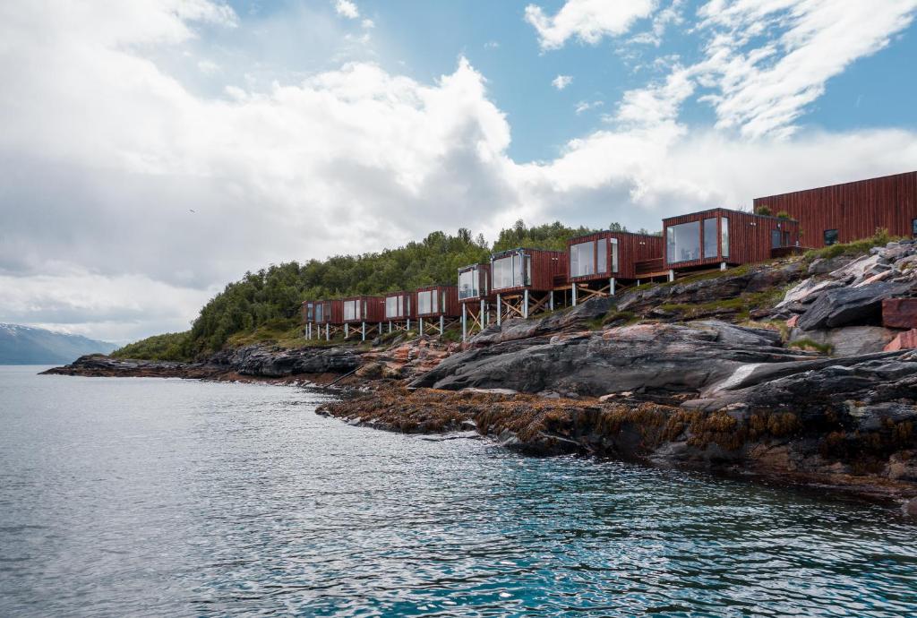 灵塞德Aurora Fjord Cabins的一条在水体旁的轨道上的火车
