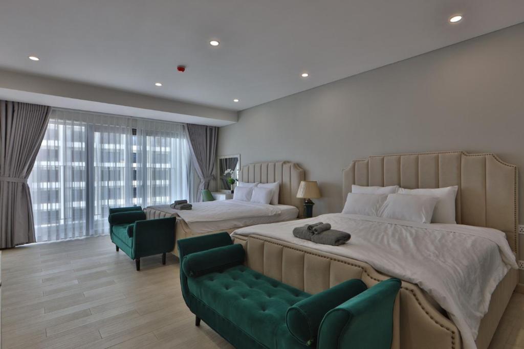 芽庄HighSea GoldCoast Superview Apartment的一间带两张床和绿色沙发的大卧室