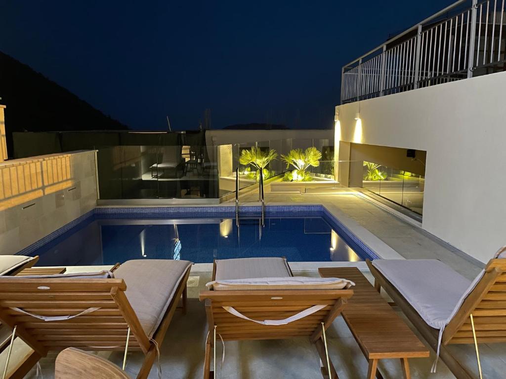 布德瓦Vistamar Hotel & Apartments的一个带躺椅的游泳池以及一座房子