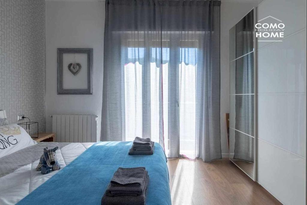 科莫Como Holiday Home Appartamento ideale per famiglie的一间卧室设有一张床和一个大窗户