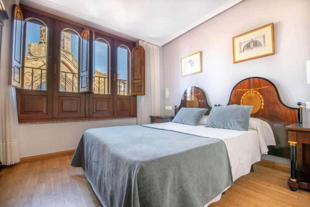 萨拉曼卡Hospedium Plaza Mayor Salamanca的一间卧室设有两张床和大窗户
