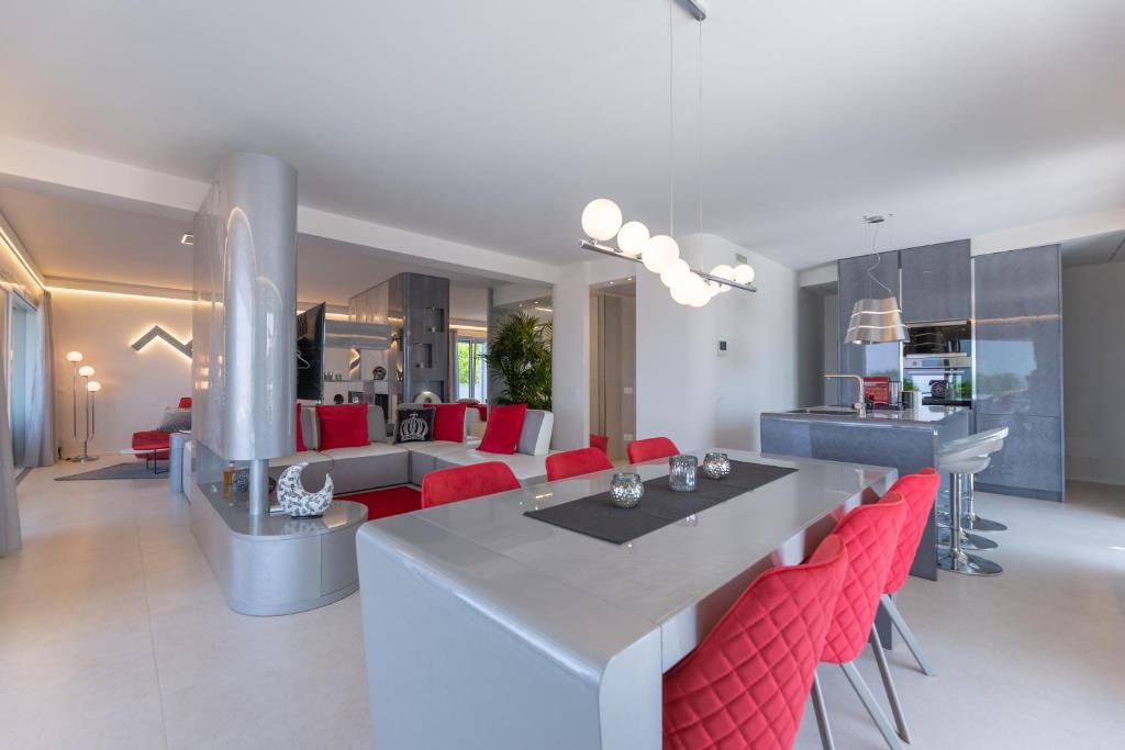 巴多利诺Magic Luxury Apartments的厨房以及带桌子和红色椅子的客厅。