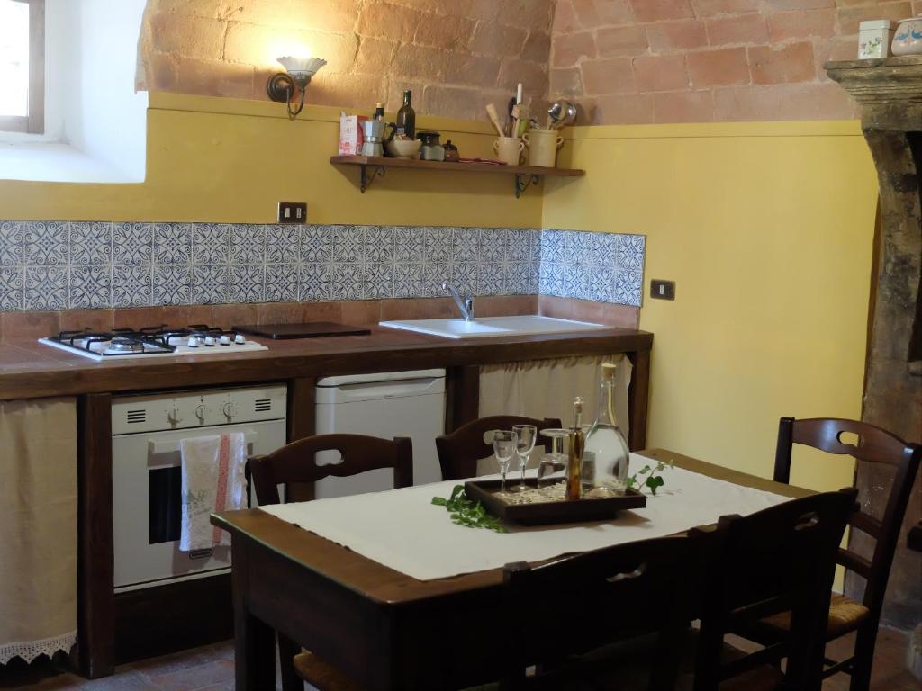 圣斯特凡诺·迪塞斯case vacanza da Rosina e T的一间带桌子的厨房和一间带黄色墙壁的厨房