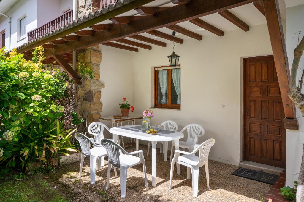 La PortillaCasa de playa toró的庭院配有白色的桌椅和木门。