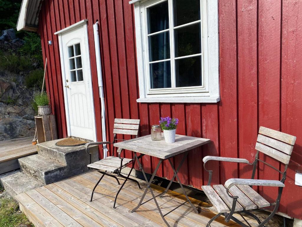 克拉格勒Bryggerhus Og Leilighet的一张桌子和椅子,坐在红楼旁边的甲板上