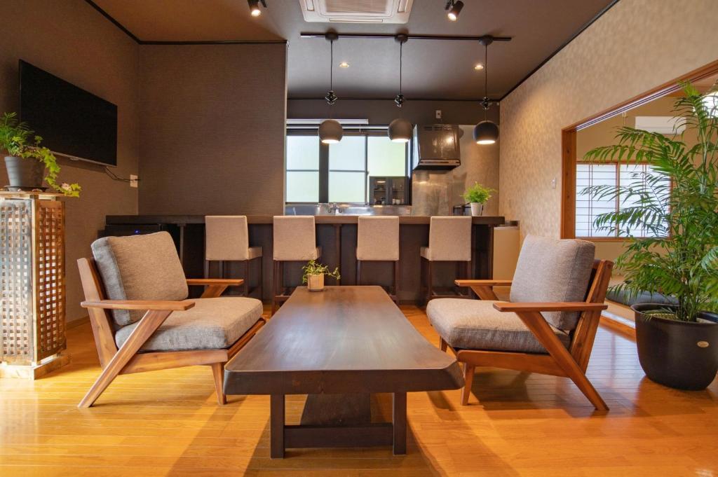 佐渡市guesthouse UZU Sado - Vacation STAY 90684v的一间带桌椅的客厅和一间厨房