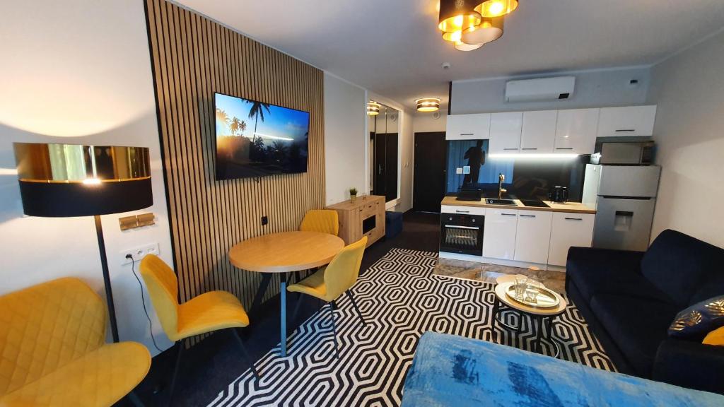 科沃布热格Gold Horizon Apartament Solny Resort的带沙发和桌子的客厅以及厨房。