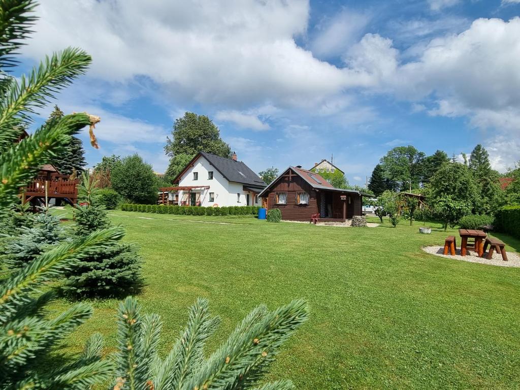 斯姆尔克山麓新城Dům a chatka pod Smrkem的一座带房子和草地的院子