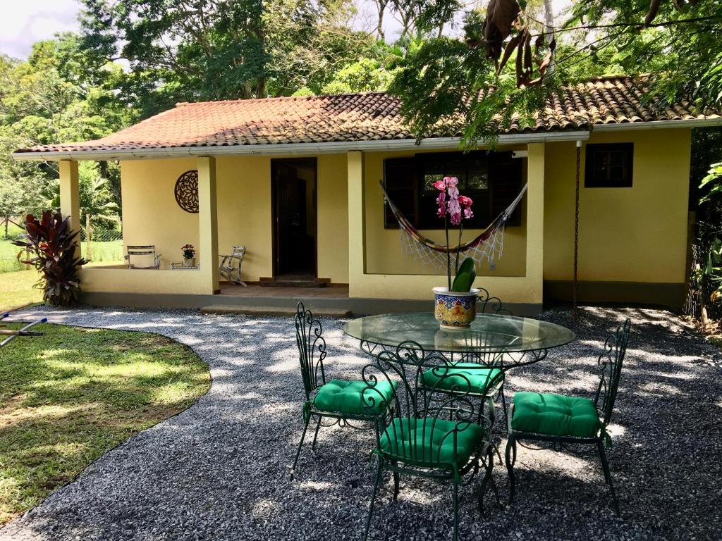 彼得罗波利斯Recanto da Floresta - Casa de campo em Secretário的房子前面的一张桌子和椅子