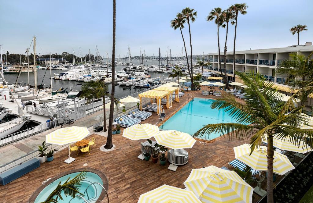 洛杉矶玛丽安德尔雷酒店的一个带遮阳伞的游泳池和一个带船只的码头