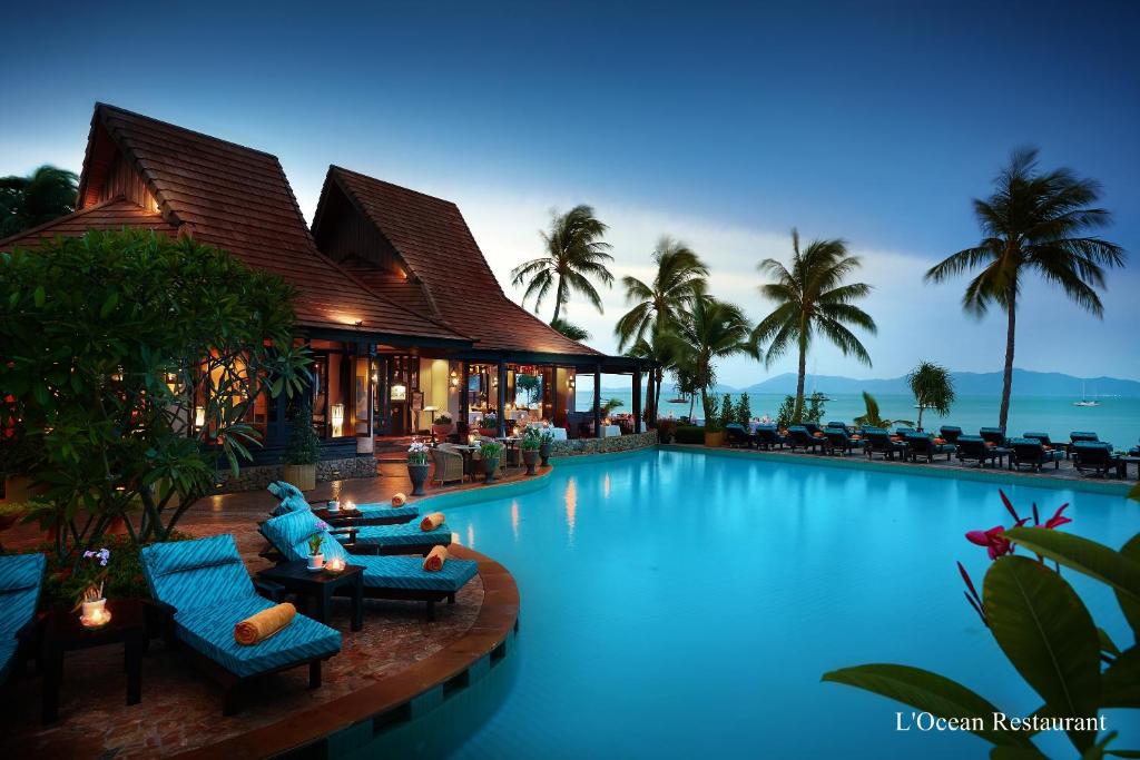 波普托Bo Phut Resort and Spa - SHA Plus的一座带椅子的游泳池以及一座建筑