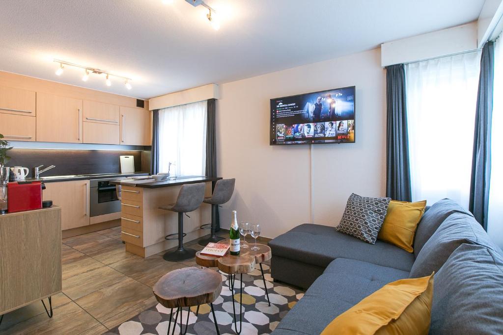 英格堡Spirit Apartments - Studio 2 - Küche - Parkplatz的一间带蓝色沙发的客厅和一间厨房