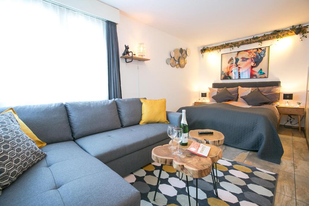英格堡Spirit Apartments - Studio 1 und 2 - Küche - Parkplatz的客厅配有蓝色的沙发和床。