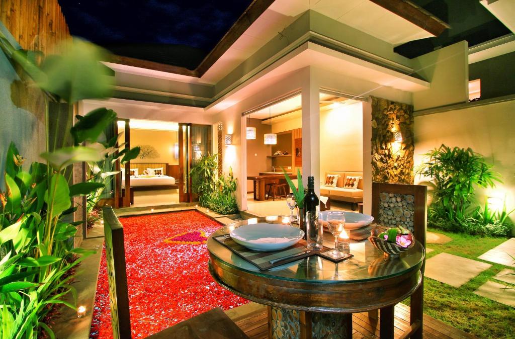 克罗柏坎Maharaja Villas Bali - CHSE Certified的一间设有桌子和红色地毯的用餐室