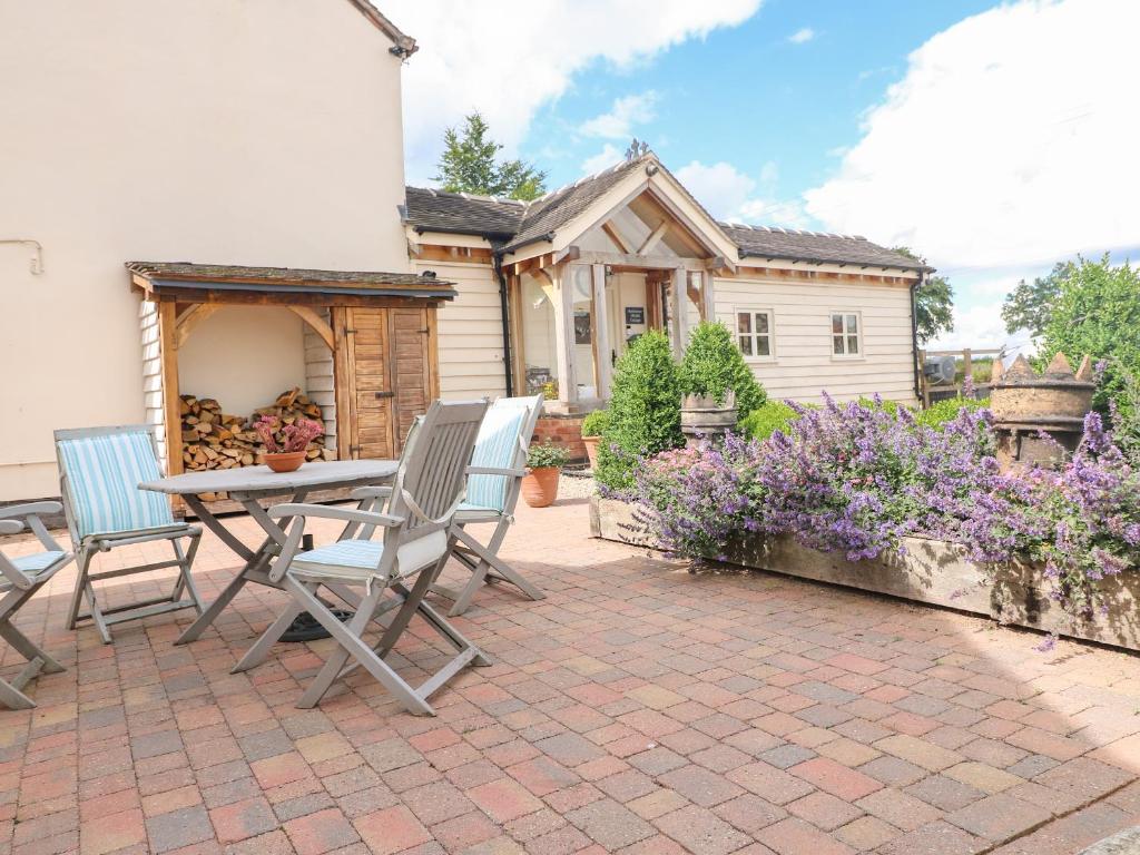 鲁吉利Bellamour End Cottage的一个带桌椅的庭院和一座房子