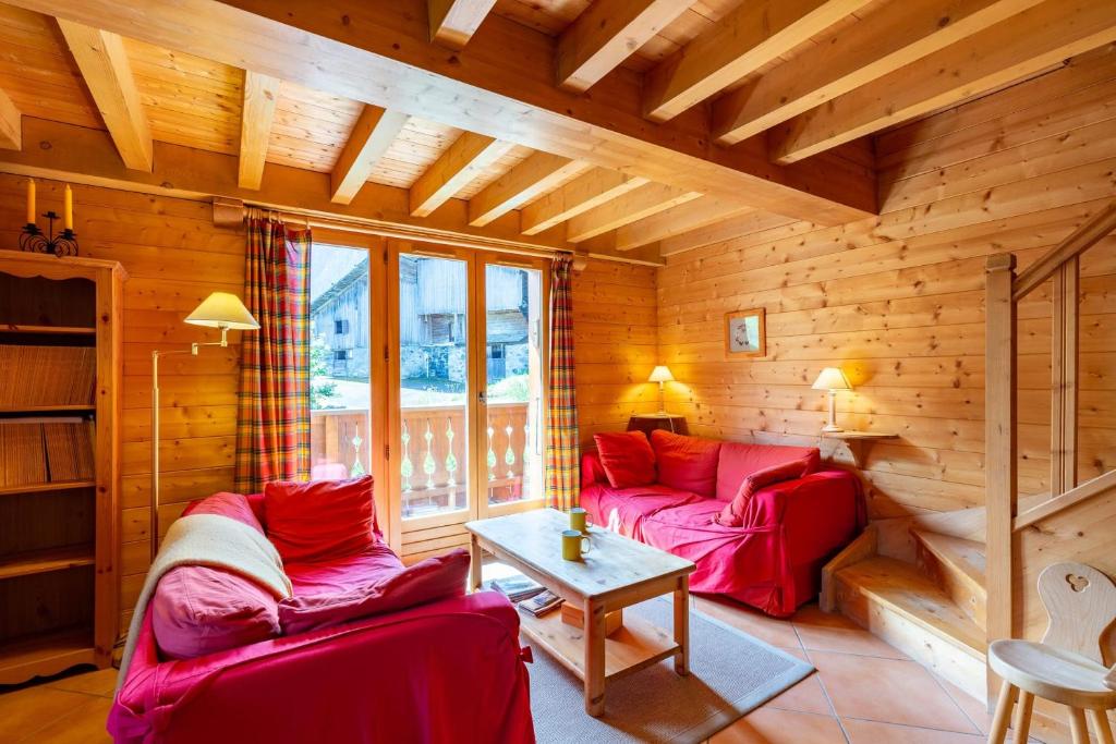 拉克吕萨Quiet apartment near the slopes的客厅配有两张红色的沙发和一张桌子