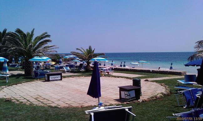 丽都玛里尼Residence Sabbiachiara的海滩上设有椅子和遮阳伞,还有大海