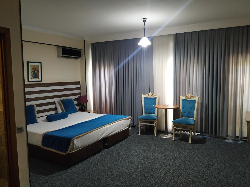 巴库巴库画廊酒店的一间卧室配有一张床、两把椅子和一张桌子