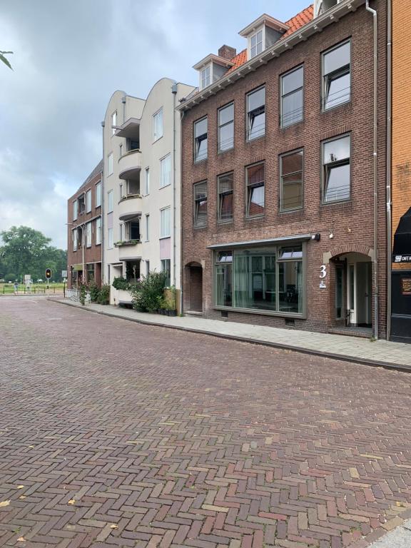 迪温特Stadshotel aan de IJssel in hartje Deventer的一条空的街道,有建筑和砖路