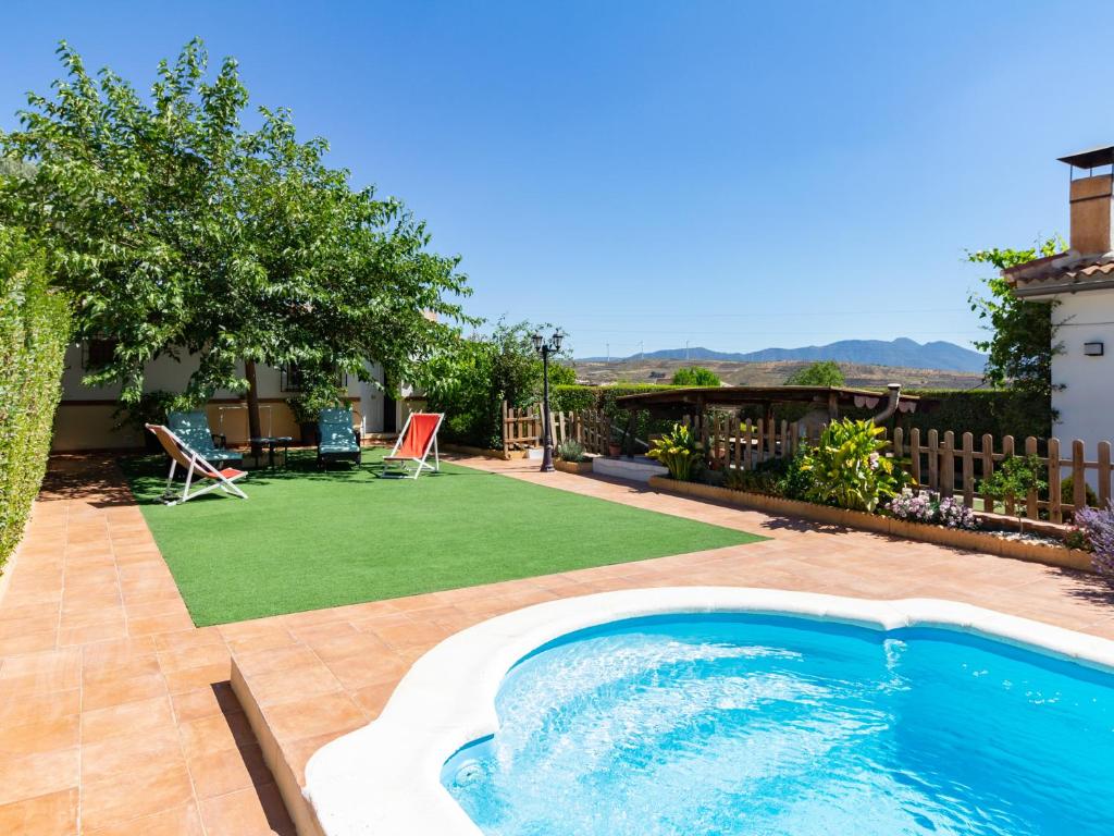 杜尔卡尔Cortijo la erilla的后院设有游泳池和草坪